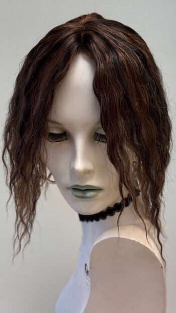 A mannequin head with long hair and green eyes.