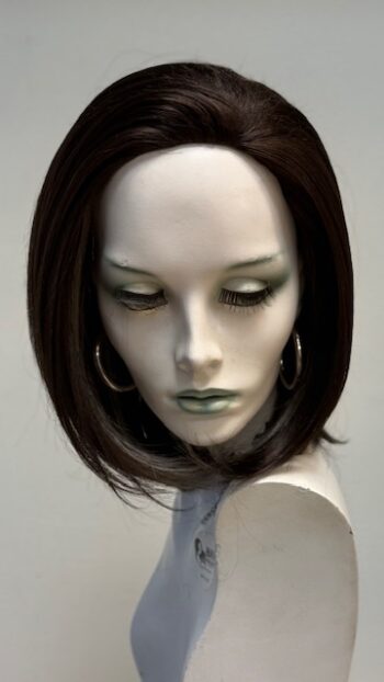 A mannequin with green eyes and dark hair.