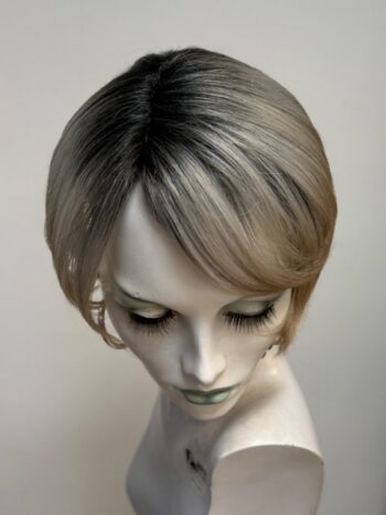 A mannequin with short hair and wearing earrings.