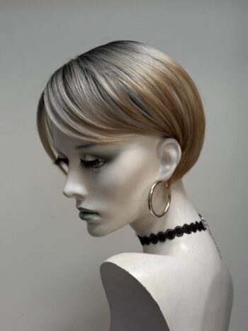 A mannequin with short hair and black jewelry.