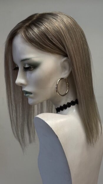 A mannequin with long hair and black jewelry.