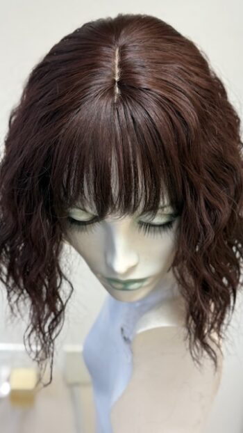 A mannequin head with long hair and bangs.