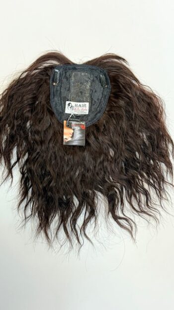 A wig with long hair hanging on the wall