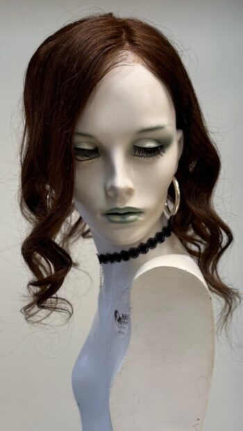 A mannequin with long hair and black jewelry.