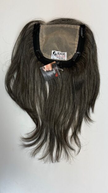 A wig with long hair hanging on the wall