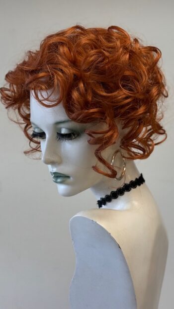 A mannequin with red hair and black jewelry.