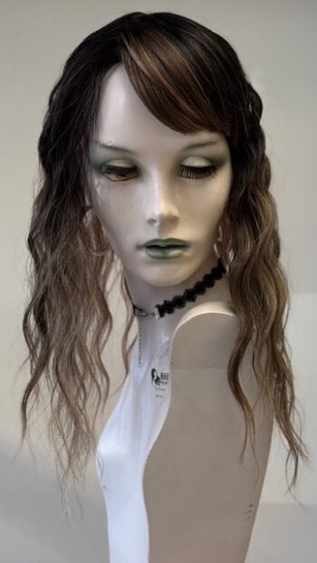 A mannequin with long hair and green lipstick.