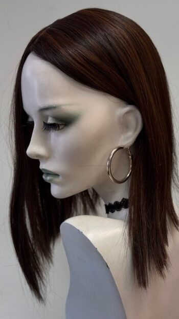 A mannequin with long brown hair and large gold hoop earrings.