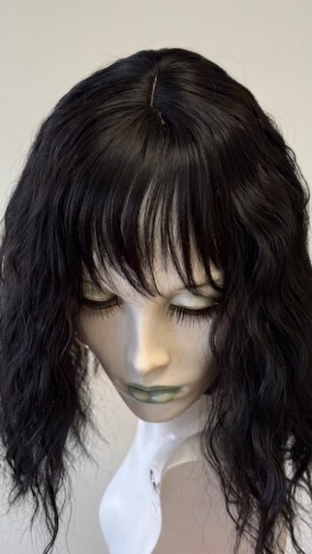 A mannequin head with long black hair and bangs.