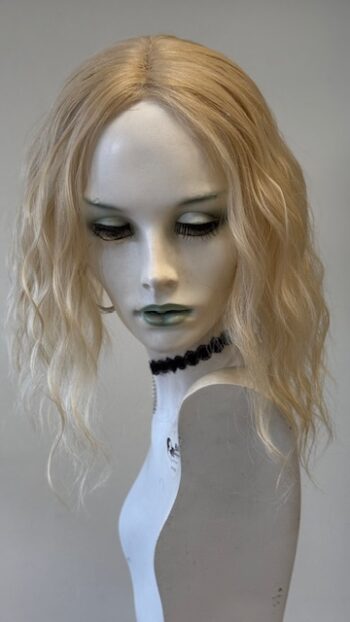 A mannequin with long blonde hair and green eyes.