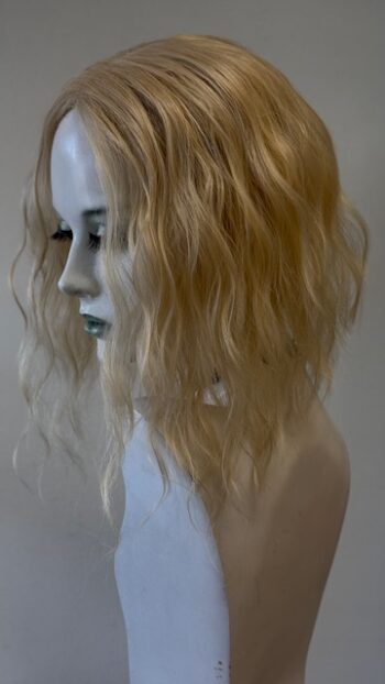 A mannequin head with blonde hair and blue eyes.