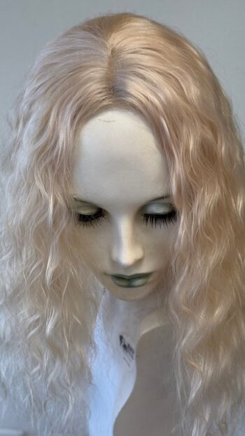 A doll with long blonde hair and green eyes.