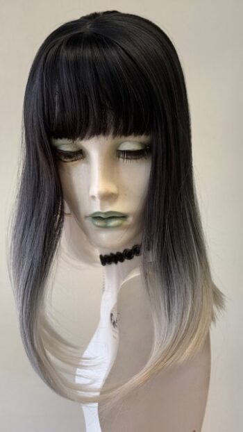 A mannequin with long black hair and white makeup.