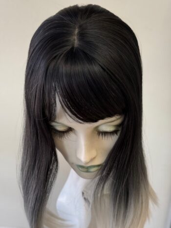 A mannequin head with long black hair and bangs.