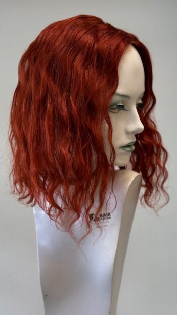 A mannequin head with red hair and green eyes.