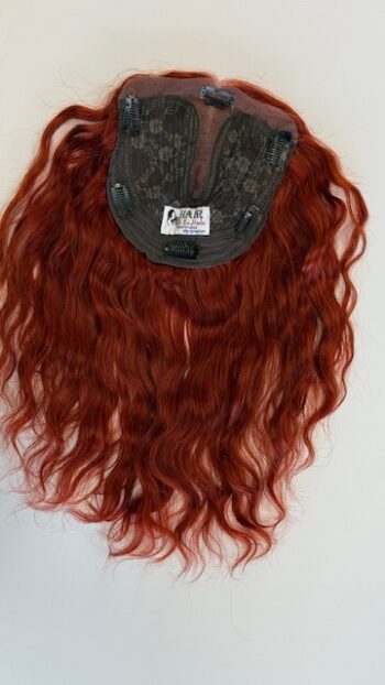 A red wig hanging on the wall