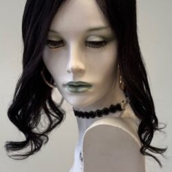 A mannequin with long black hair and green lipstick.