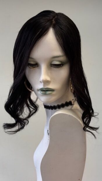 A mannequin with long black hair and green lipstick.