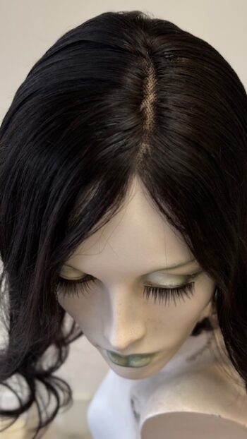 A close up of the face of a woman with long black hair.