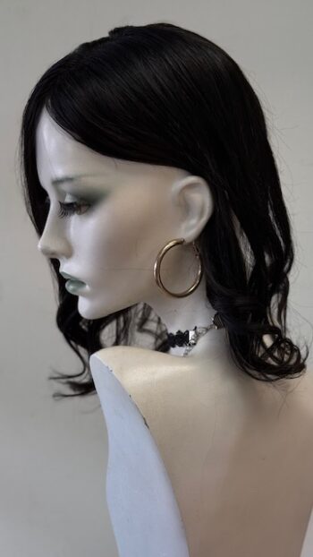 A mannequin wearing large hoop earrings and a necklace.