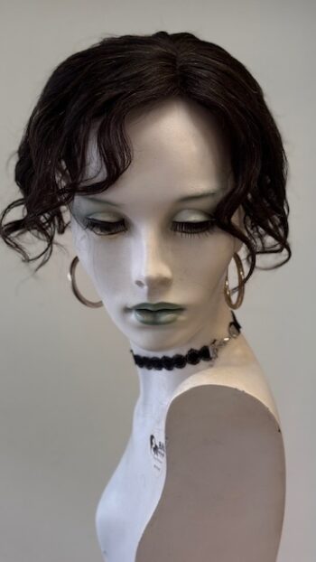 A mannequin with black hair and green eyes.