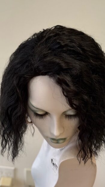 A mannequin head with long black hair.