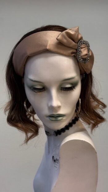 A mannequin wearing a brown hat and earrings.