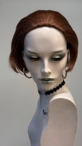 A mannequin with green eyes and black makeup.