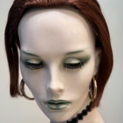 A mannequin with green eyes and red hair.