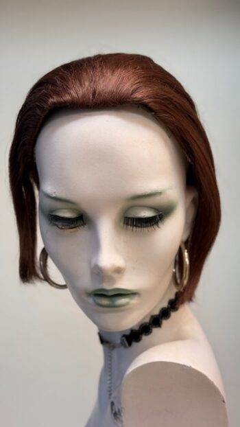 A mannequin with green eyes and red hair.