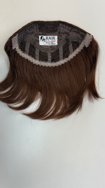 A brown wig hanging on the wall