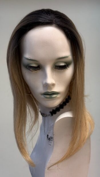 A mannequin with long blonde hair and green eyes.