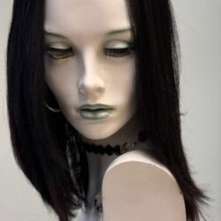 A mannequin with black hair and green lipstick.