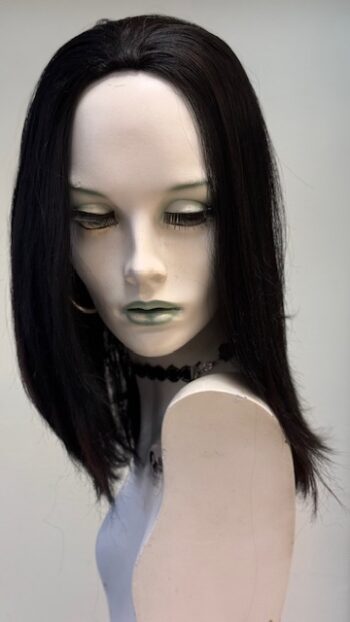 A mannequin with black hair and green lipstick.