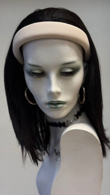 A mannequin head with green eyes and black hair.