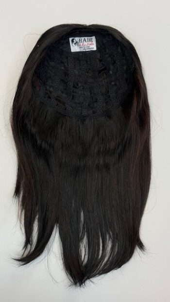 A black wig is hanging on the wall.