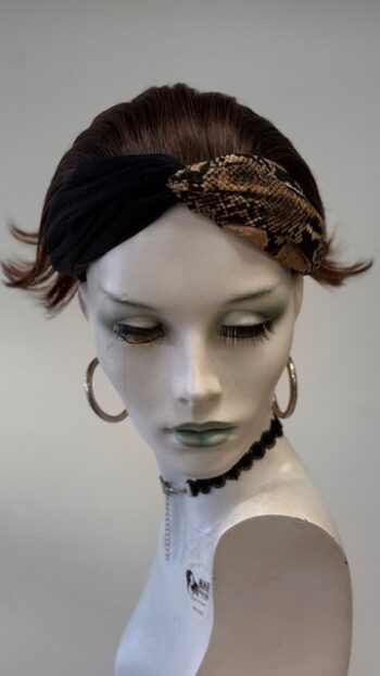 A mannequin wearing a head band and earrings.