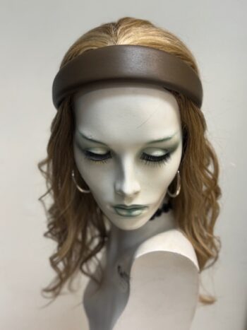 A mannequin wearing a brown headband and earrings.