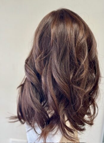 A woman with long brown hair is standing.