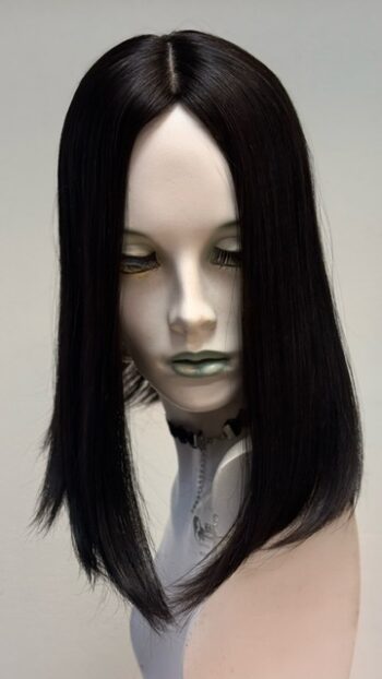 A mannequin with long black hair and green eyes.