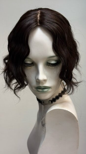 A mannequin with black hair and green eyes.