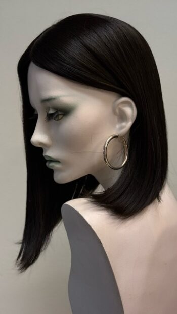 A mannequin with long black hair and large gold hoop earrings.