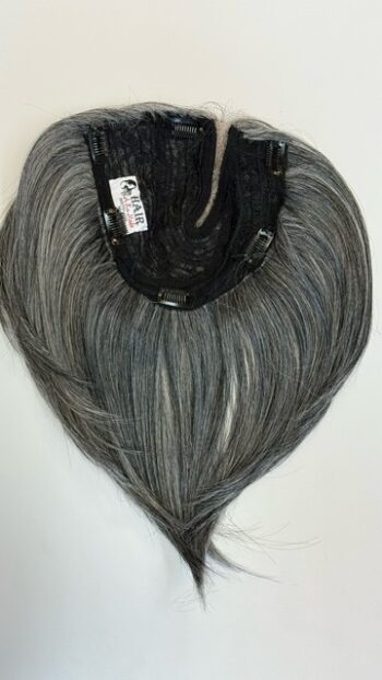 A black and grey wig hanging on the wall