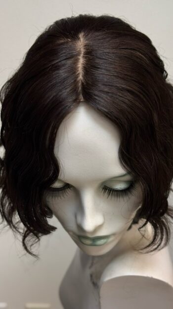 A mannequin head with long eyelashes and dark hair.