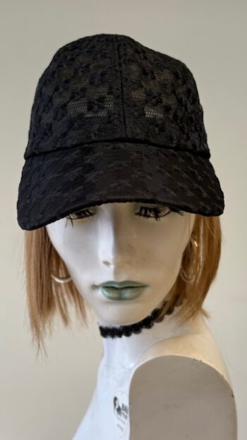 A mannequin wearing a black hat with a pattern.