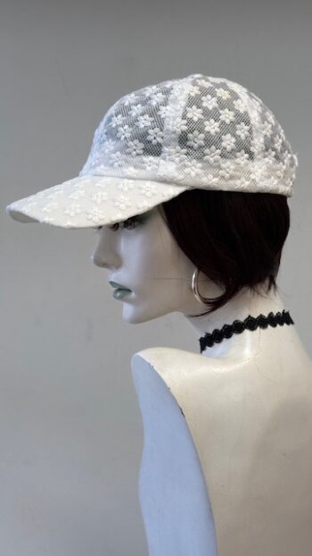 A mannequin wearing a white hat and black choker.