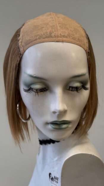 A mannequin head with long hair and green eyes.