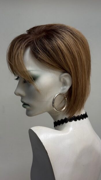 A mannequin with short hair and black jewelry.