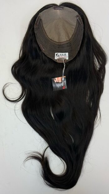 A wig hanging on the wall with a tag