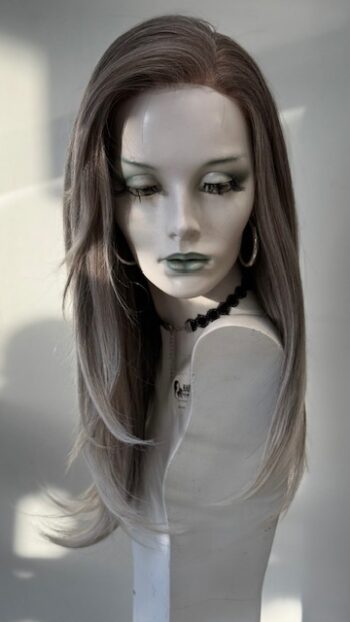 A mannequin with long hair and green lipstick.